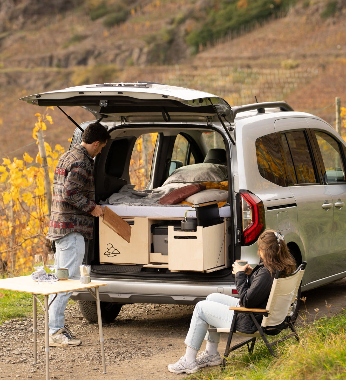 Renault Kangoo mit Campingbox und offener Heckklappe zwischen herbstlichen Weinbergen