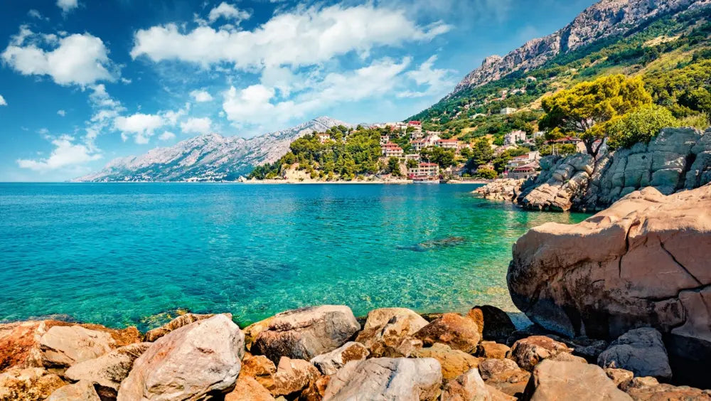 Türkisblaue Bucht mit Felsen und Bergkulisse an der kroatischen Adriaküste