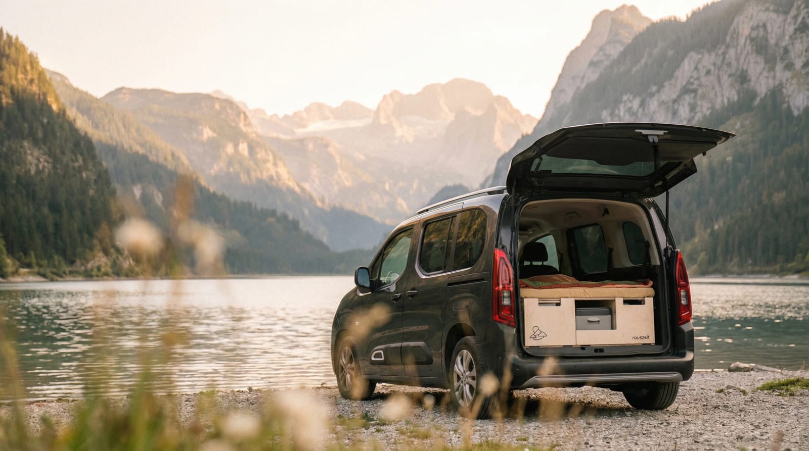 Hochdachkombi mit Campingbox am Bergsee im Abendlicht