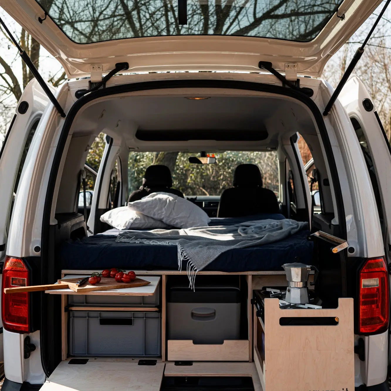 Campingbox mit ausgezogenem Schiebebett und Kochmodul im Hochdachkombi