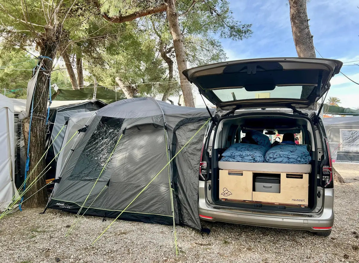 VW Caddy Maxi mit Campingbox und Vorzelt auf Campingplatz in Spanien
