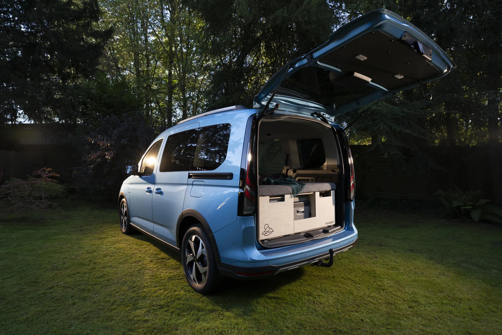 Ford Tourneo Connect am Abend mit offener Heckklappe, Rauszeit Campingbox eingebaut, Bett zusammengeschoben