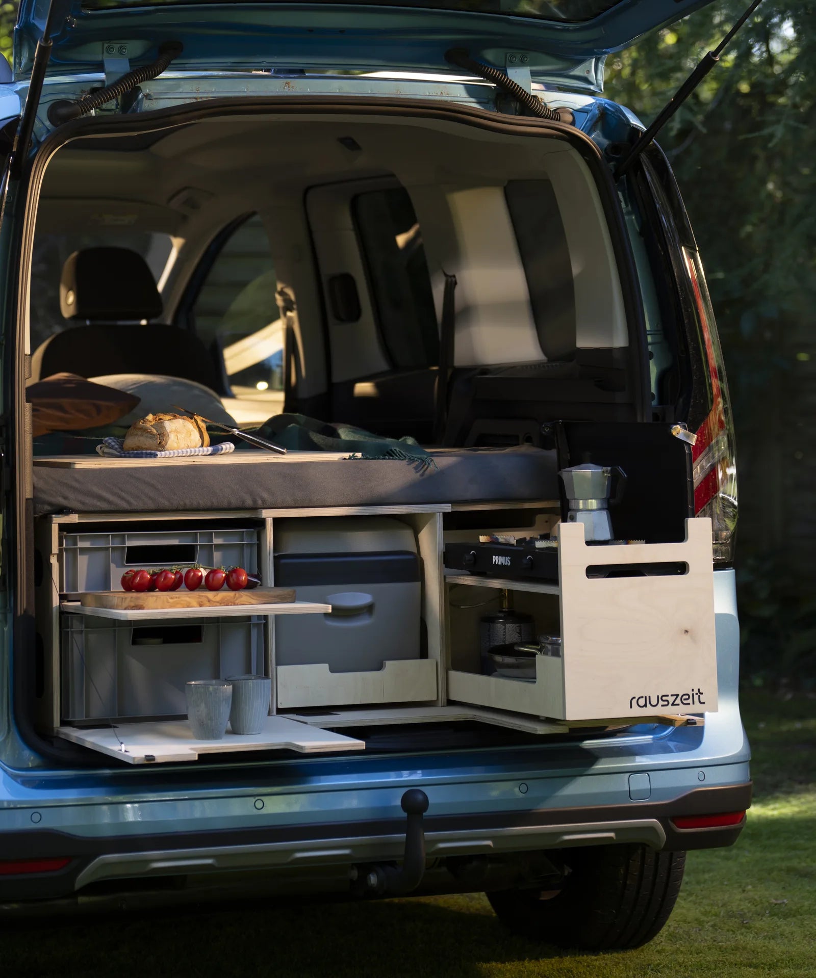 Rauszeit Campingbox im Heck eines Ford Tourneo Connect, leicht seitlich: Bett, Euroboxen, Kühlbox und Kochmodul