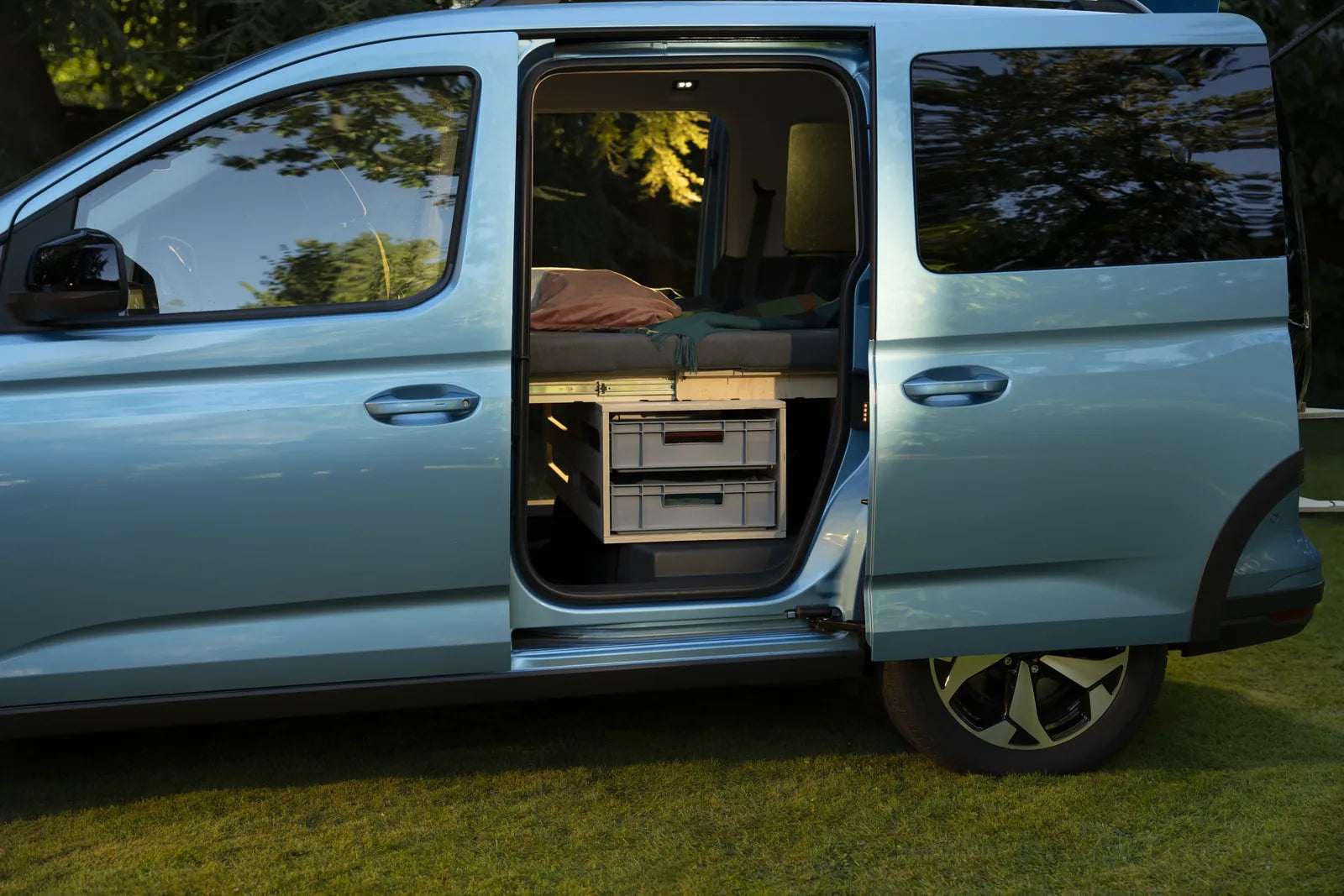 Blick durch die Schiebetür eines Ford Tourneo Connect auf das Bett und die Euroboxen-Schubfächer der Rauszeit Campingbox
