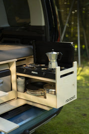 Kochmodul der Campingbox schräg von der Seite im Heck, mit Gaskocher, Espressokanne, Töpfen und Rauszeit-Logo